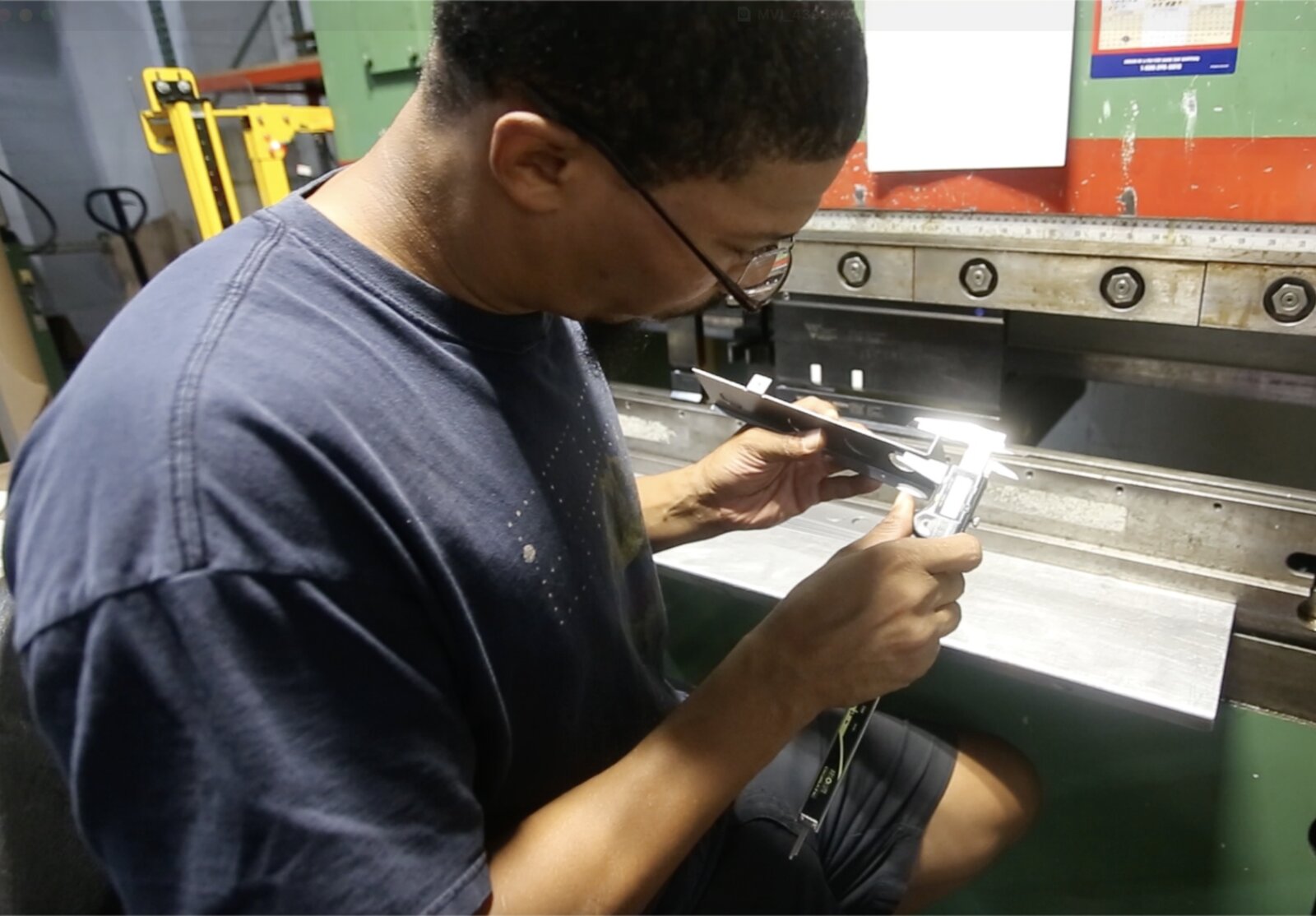 Renova technician measuring a fixture component with calipers for quality control