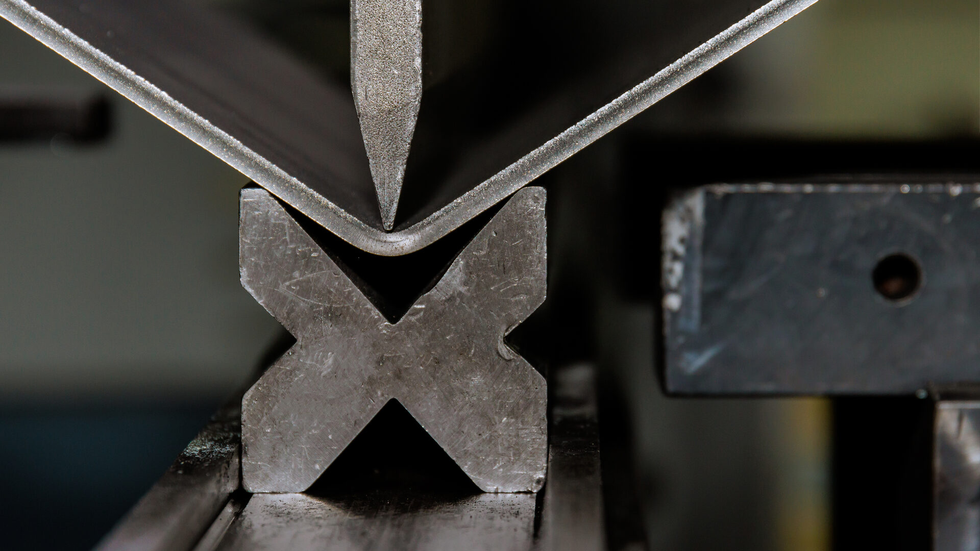 Close-up of sheet metal being bent on a press brake